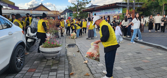 지난달 경북 경주시 황리단길에서 경주 착한가격업소연합회 회원들이 환경정화 활동을 펼치고 있다. 사진 경주시