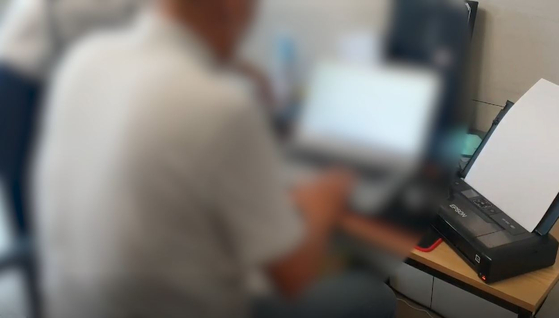 경기남부경찰청 사이버수사과 수사관이 해킹·피싱 범행에 사용한 노트북 앞에 앉은 조직원에게 체포영장과 압수수색 영장 집행 절차를 설명하고 있다. 사진 경기남부경찰청