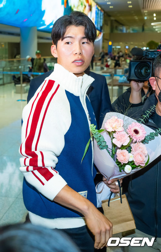 [OSEN=인천공항, 민경훈 기자] 미국프로야구 메이저리그(MLB)LA 다저스의 김혜성이 6일 오후 인천국제공항을 통해 귀국했다.김혜성은 메이저리그 진출 첫 해 우승반지를 거머쥐는 영광을 누렸다. 한국인 메이저리거 야수로는 역대 최초로 월드시리즈 우승반지를 차지한 김혜성은 올해 71경기 출전, 타율 0.280(161타수 45안타), 3홈런 17타점 19득점, 13도루(1실패), 출루율 0.314 장타율 0.385, OPS 0.699의 기록으로 정규시즌을 마무리했다.김혜성이 입국장 앞에서 팬들에게 꽃다발을 받고 있다. 2025.11.06 /rumi@osen.co.kr