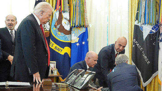  도널드 트럼프 미국 대통령과 글로벌 제약사 대표들이 6일(현지시간) 백악관 집무실에서 열린 비만치료제 가격 인하 발표 현장에서 한 참석자가 쓰러진 뒤 상황을 지켜보고 있다. AP=연합뉴스