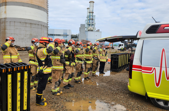 한국동서발전 울산화력발전소 보일러타워 붕괴 사고 나흘째인 9일 소방대원들이 매몰자 시신을 수습한 뒤 거수 경례를 하고 있다. 사진 울산소방본부