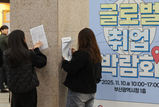 10일 부산시청 대회의실과 대강당에서 열린 '2025 부산청년 글로벌 취업박람회'를 찾은 청년구직자들이 벽에 기대어 설문지를 작성하고 있다. 연합뉴스