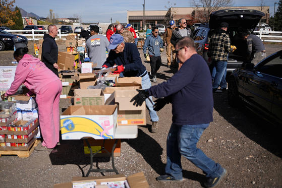  7일(현지시간) 미국 콜로라도주 콜로라도스프링스의 마운트카멜 재향군인복지센터 식품 배급소에서 자원봉사자들이 식료품 상자를 차량에 실을 준비를 하고 있다. 연방정부 셧다운이 수주째 이어지는 가운데 이날 100대가 넘는 차량이 배급소를 찾았다. 로이터=연합뉴스