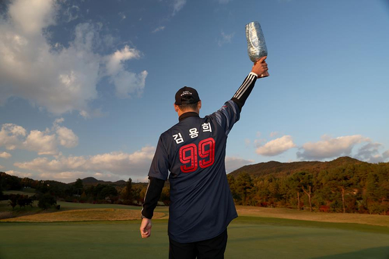 김재호가 2일 열린 KPGA 투어 렉서스 마스터스에서 프로 데뷔 17년 만에 우승한 뒤 아버지인 김용희 롯데 자이언츠 2군 감독의 유니폼을 입고 우승 트로피를 들고 있다. [연합뉴스]