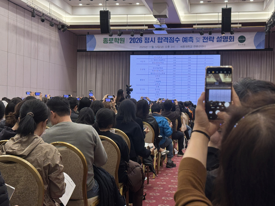 14일 서울 광진구 세종대 컨벤션센터에서 열린 대입 전략 설명회에서 학부모들이 각 대학 예상 합격 점수가 발표되자 사진을 찍고 있다. 이보람 기자