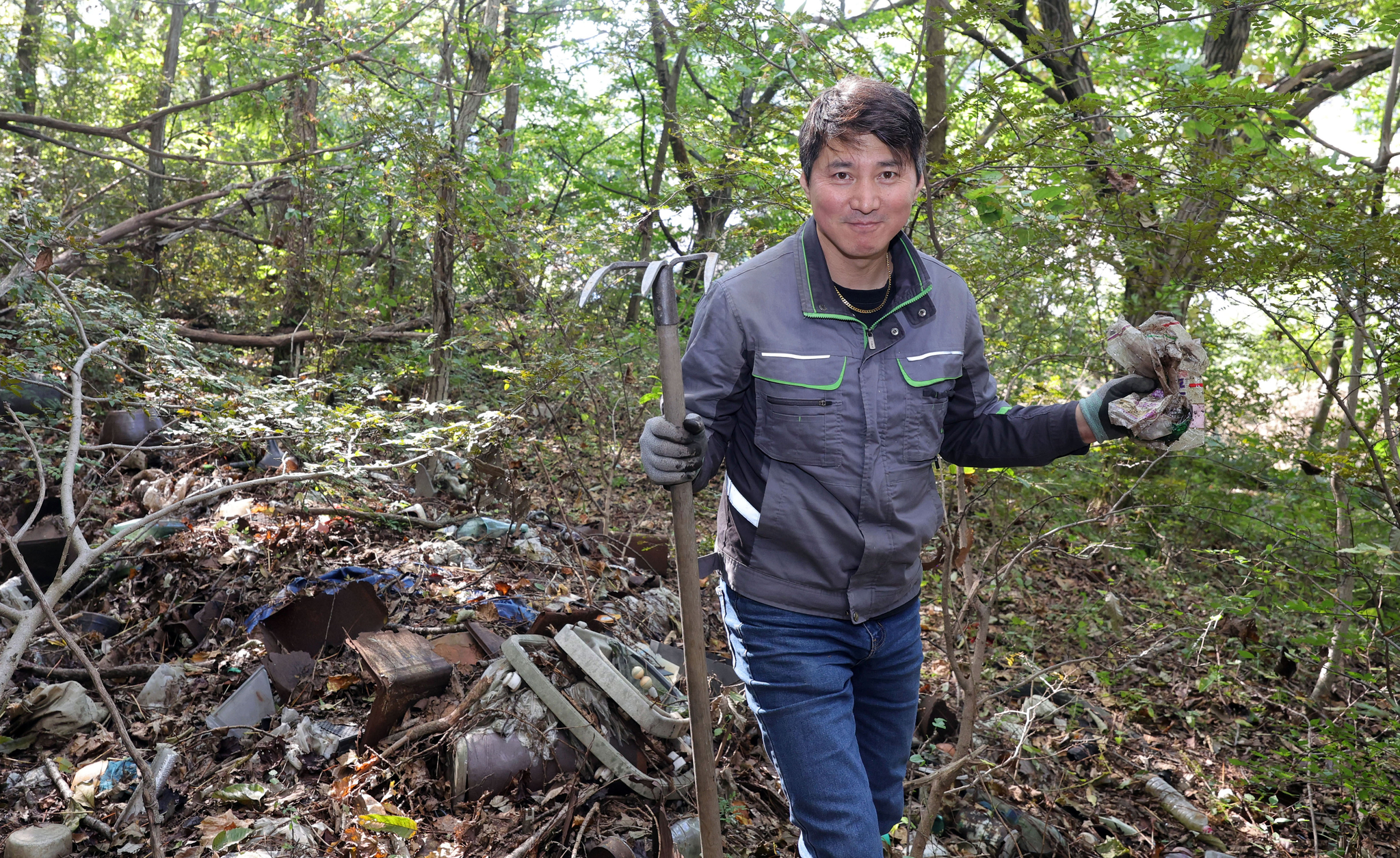 전국 산야를 돌며 25년째 추억을 발굴하는 이이교 과자박물관 '인천상회' 관장이 지난달 23일 석모도의 한 폐가 뒷산에서 80년대 빵봉지를 수거하고 있다. 강정현 기자