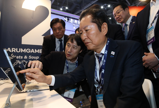 정청래 더불어민주당 대표가 14일 오후 부산 해운대구 벡스코 제1전시장에서 열린 국내 최대 게임전시회 '지스타 2025'에서 부스를 둘러보며 게임을 체험하고 있다. 뉴스1