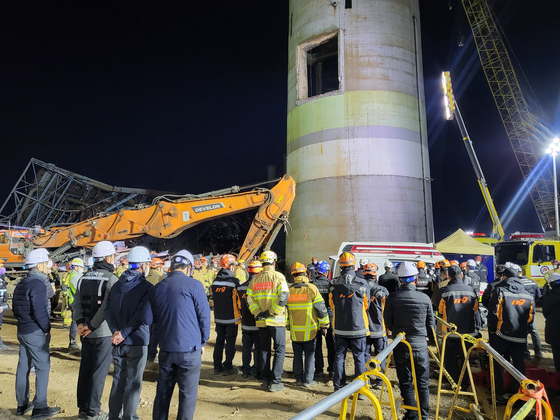 지난 14일 오후 울산화력발전소 붕괴 현장에서 마지막 매몰자를 수습하고 병원으로 이송하기 앞서 모든 현장 관계자들이 도열해 고인에 대한 예를 갖추고 있다. 사진 뉴스1