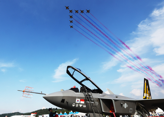 지난 10월 경기도 성남시 서울공항에서 열린 '서울 국제항공우주 및 방위산업 전시회(ADEX)'에서 공군 특수비행팀 블랙이글스가 전시 중인 KF-21 위로 비행하고 있다. 연합뉴스