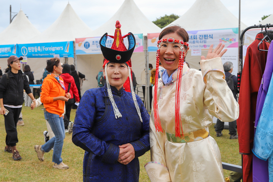 8일 제주올레 걷기축제에 참가한 대만인 여행객(오른쪽)이 몽골 올레 부스에서 몽골 전통 의상을 입고 즐거워하는 모습. 최승표 기자