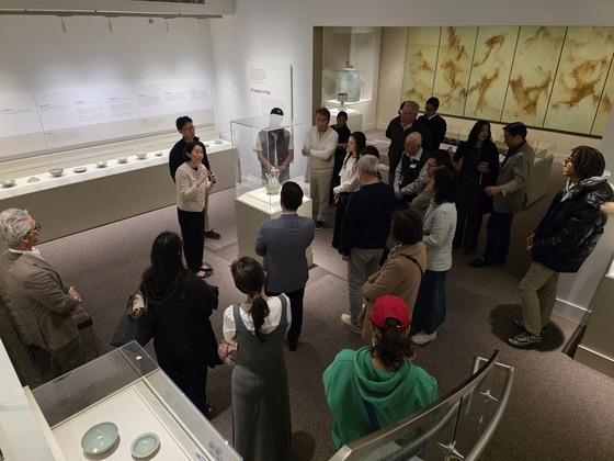 15일(현지시간) 미국 워싱턴 스미스소니언 국립아시아미술관에서 개막한 이건희 회장 기증품 해외 순회전 ‘한국의 보물: 모으고, 아끼고, 나누다’를 안내하는 황선우 KF한국미술문화 담당 큐레이터. 맨 왼쪽은 체이스 로빈슨 관장. 김병기의 ‘산악’ 7폭 연작(맨 오른쪽 그림)부터 청자와 백자까지 한국의 고미술과 현대미술이 한데 어우러졌다. 사진 강임산 소장