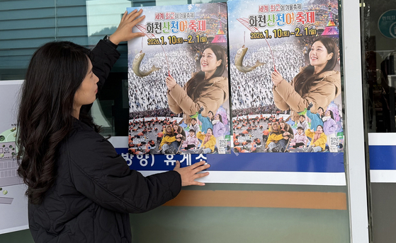 강원도 화천군청 관광정책과 직원이 지난 14일 고속도로 휴게소를 방문해 '2026 화천산천어축제' 포스터를 붙이는 모습. [사진 화천군]