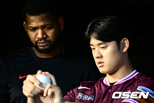 키움 히어로즈 라울 알칸타라가 정현우에게 그립을 설명하고 있다. /OSEN DB