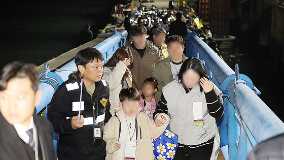 지난 19일 오후 전남 목포시 목포해양경찰서 전용부두로 좌초된 여객선 퀸제누비아2호 탑승객들이 구조돼 이동하고 있다. 연합뉴스