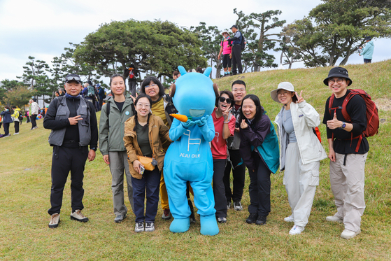 지난 8일 제주올레 걷기축제에 참가한 중국인들이 제주올레 마스코트 ‘간세’와 기념 사진을 찍었다. 최승표 기자