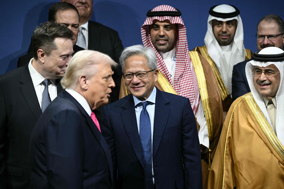 도널드 트럼프 미 대통령이 19일(현지시간) 미 워싱턴DC의 케네디 공연예술센터에서 열린 ‘미·사우디 투자 포럼’에서 일론 머스크 테슬라 최고경영자(왼쪽), 젠슨 황 엔비디아 창업자 겸 최고경영자(가운데) 앞을 지나 기념 촬영을 위해 이동하고 있다. [AFP=연합뉴스]