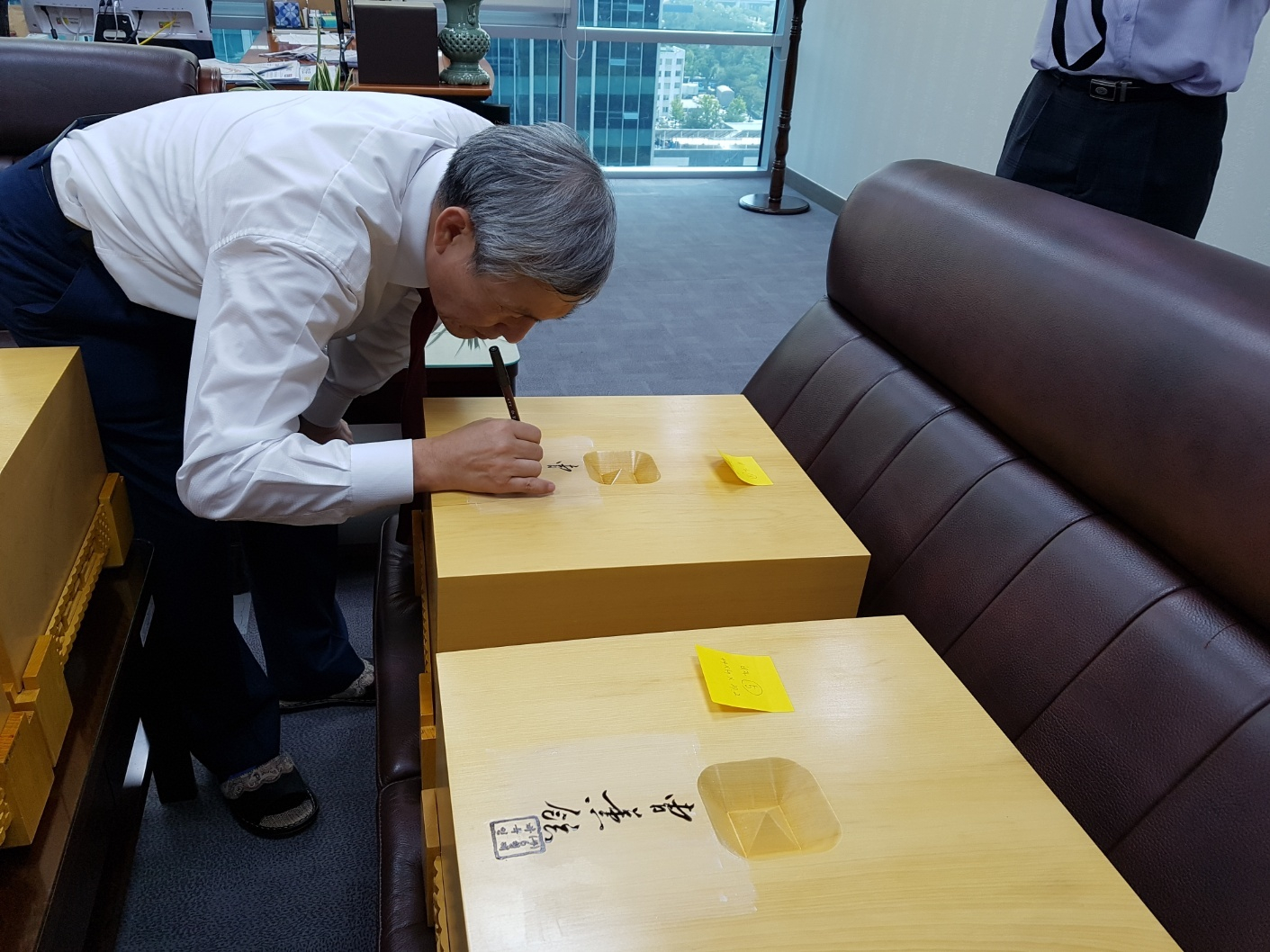 조훈현 국수가 6형제바둑 바둑판을 전달받으며 바둑판에 서명하고 있다. [사진 6형제바둑]