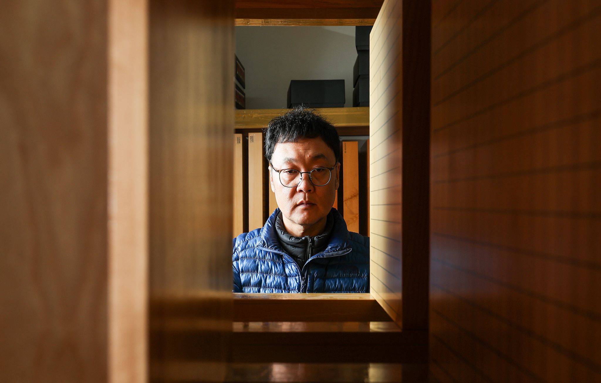 신동관 본부장이 바둑판 저장소에서 바둑판을 살펴보고 있다. 완성된 바둑판은 작은 흠집이라도 생기지 않도록 체계적으로 보관한다. 신 본부장은 "돌을 놓는 순간 새 상품으로서의 값어치가 떨어진다"고 밝혔다.