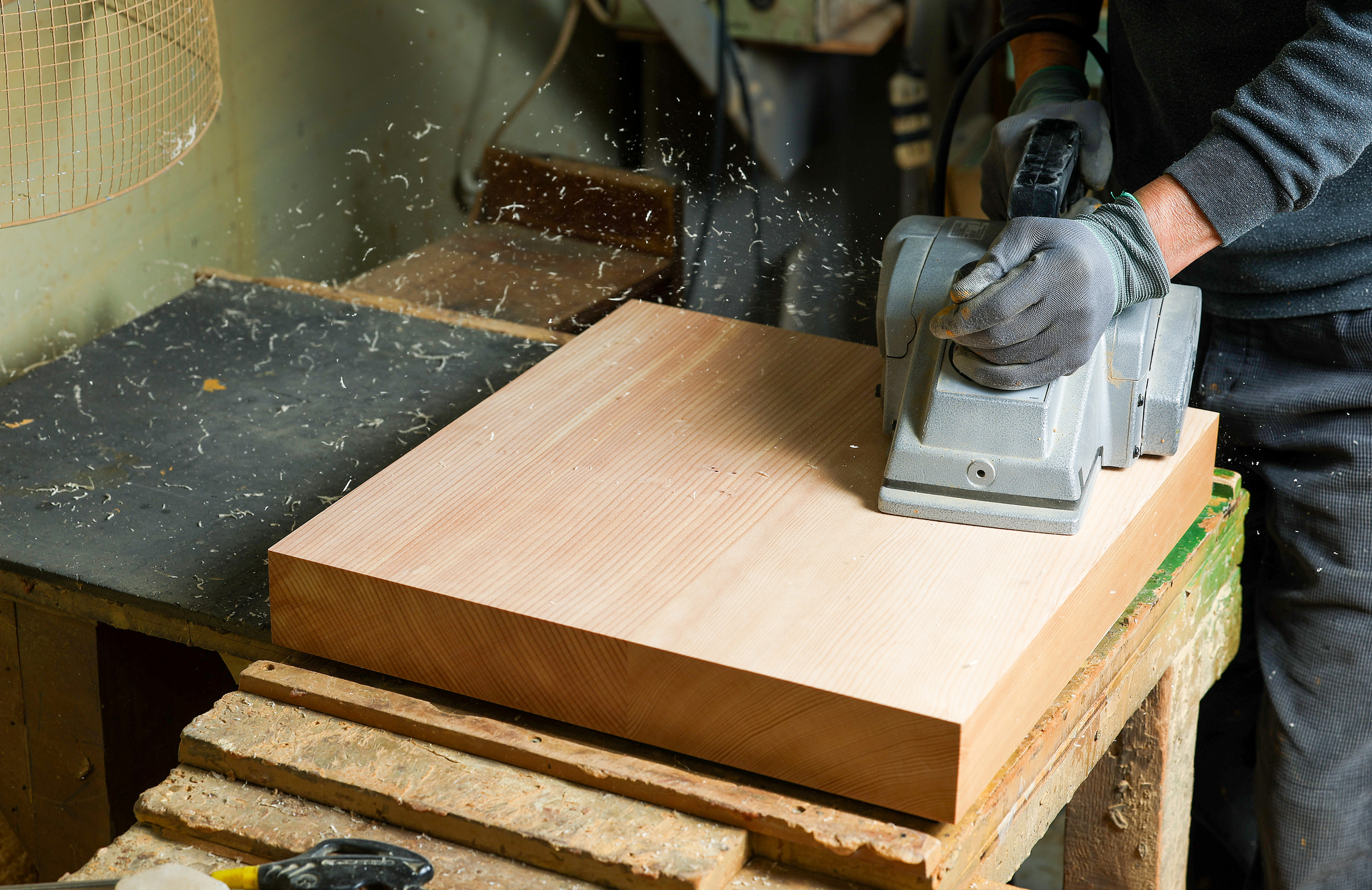 재단된 원목을 평평하게 대패로 깍아내고 있다. 