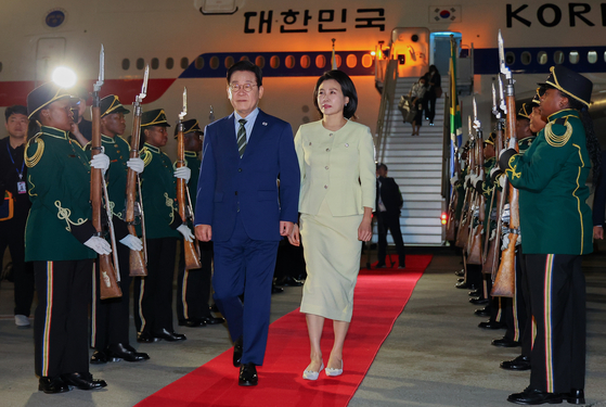 주요 20개국(G20) 정상회의에 참석하는 이재명 대통령이 김혜경 여사와 함께 21일(현지시간) 남아프리카공화국 요하네스버그 OR탐보국제공항에 도착한 뒤 공군 1호기에서 내려 이동하고 있다. 연합뉴스