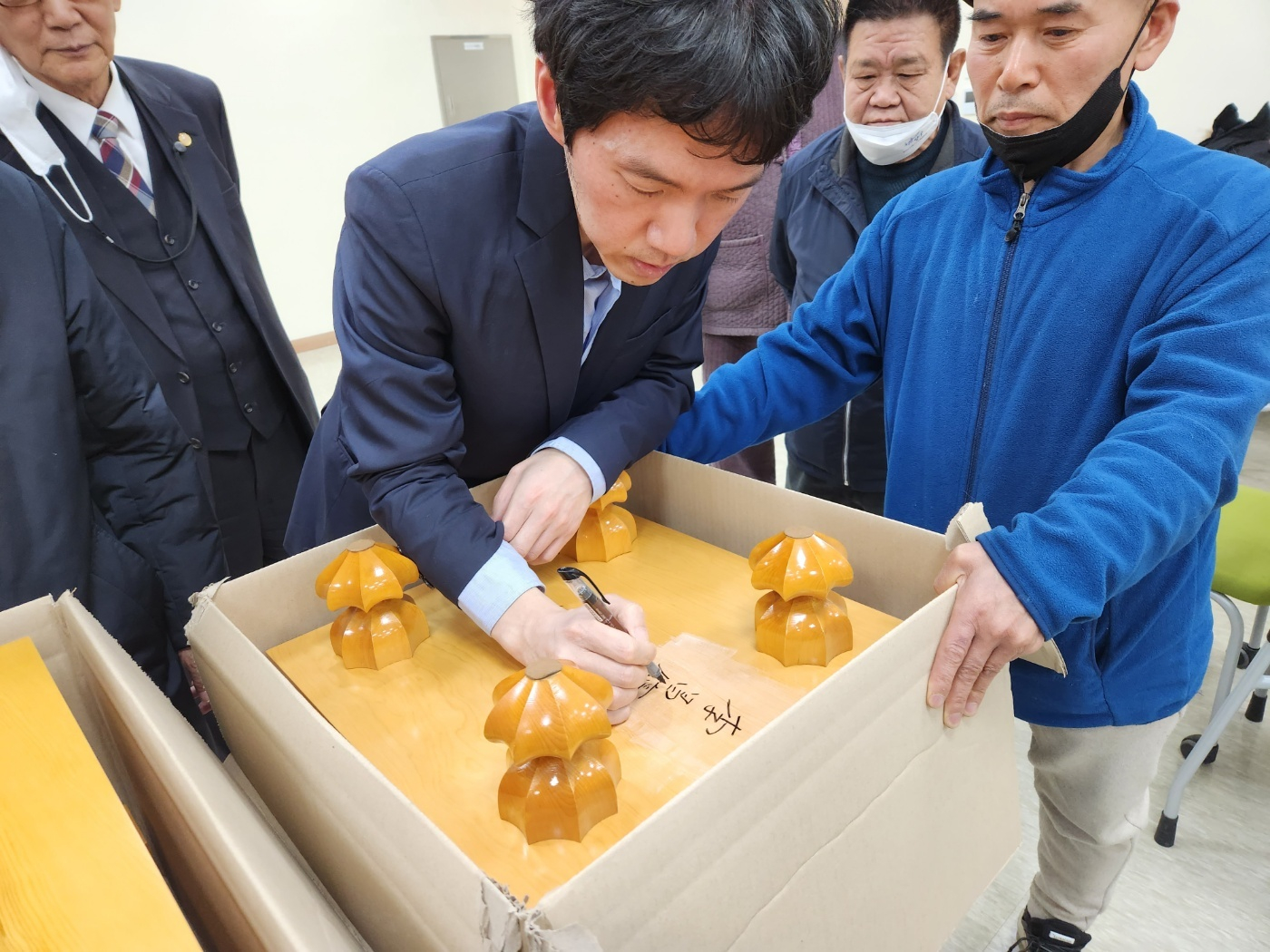 이창호 국수가 6형제바둑 바둑판을 전달받으며 서명하고 있다. [사진 6형제바둑]