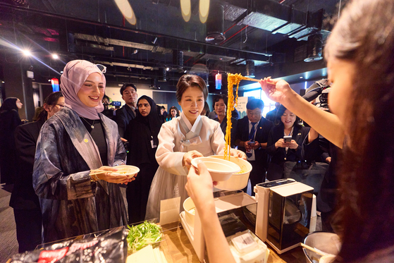 이재명 대통령의 부인 김혜경 여사가 19일(현지시간) 아랍에미리트의 한국문화원에서 열린 할랄 인증 K-Food 홍보 행사에 참석해 불닭볶음면을 시식하고 있다. [대통령실사진기자단] 