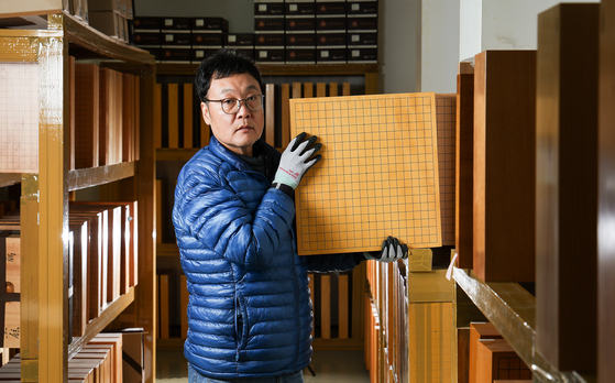  신 본부장이 본비자 바둑판을 들어보이고 있다.