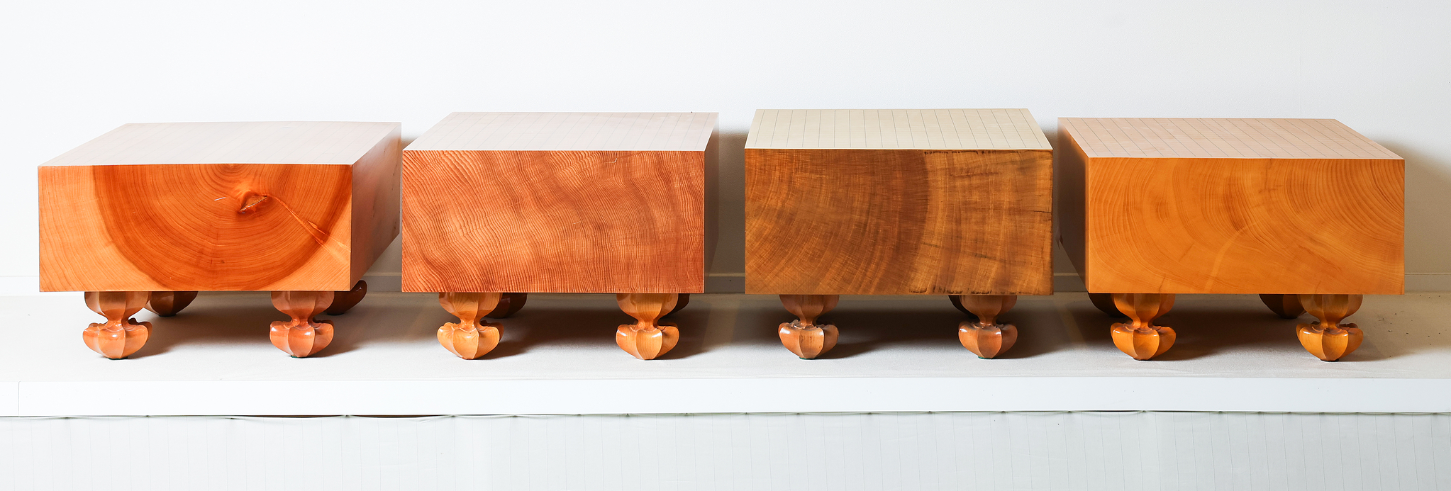 완성된 다양한 품질의 바둑판. 나이테의 중심부가 포함된 하급 바둑판부터 색이나 결이 고른 상급 바둑판이 왼쪽부터 순서대로 놓여있다. 맨 오른쪽은 본비자 바둑판. 