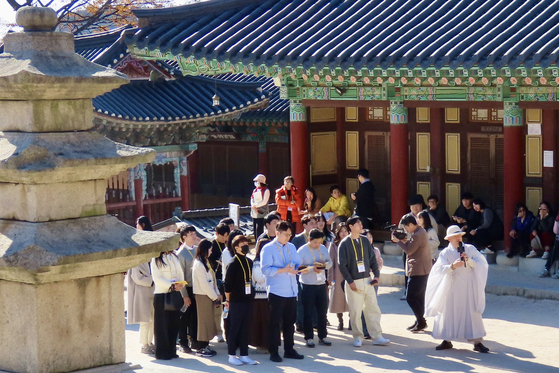 지난 11월15일 '나는 절로-수덕사 편'에 참가한 남녀 20명이 대웅전 앞에서 사찰의 연혁을 경청하고 있다. 이날 수덕사를 찾은 나들이객 1000여 명은 이들에게 큰 관심을 보였다. 김홍준 기자