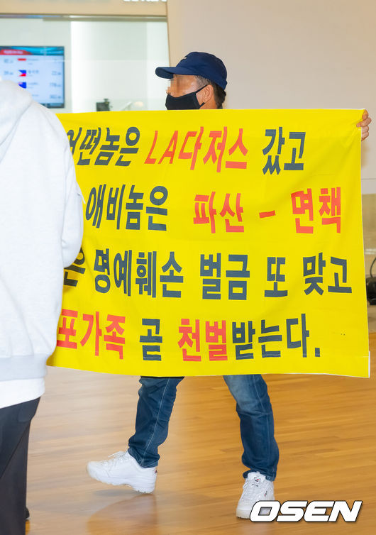 [OSEN=인천공항, 민경훈 기자] 미국프로야구 메이저리그(MLB)LA 다저스의 김혜성이 6일 오후 인천국제공항을 통해 귀국했다.김혜성은 메이저리그 진출 첫 해 우승반지를 거머쥐는 영광을 누렸다. 한국인 메이저리거 야수로는 역대 최초로 월드시리즈 우승반지를 차지한 김혜성은 올해 71경기 출전, 타율 0.280(161타수 45안타), 3홈런 17타점 19득점, 13도루(1실패), 출루율 0.314 장타율 0.385, OPS 0.699의 기록으로 정규시즌을 마무리했다.김혜성이 입국장 앞에서 인터뷰를 할때 한 남성이 비난 현수막을 펼치고 있다. 2025.11.06 /rumi@osen.co.kr