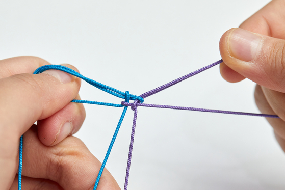 생쪽매듭은 전통매듭 중 가장 폭넓게 사용하는 기초 매듭으로 노리개·팔찌·장신구 등 다양한 곳에 활용한다. 중심 고리를 만들고 양쪽 끈을 교차해 ‘우물 정(井)’자 모양을 만들면 된다.