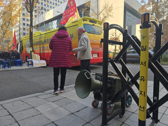 한 장애인 단체가 지난 20일 오전 서울 여의도의 한 증권사 앞에서 약정 기부금을 내놓으라며 버스와 확성기 등을 동원해 해당 증권사에 재직 중인 임원을 규탄하는 집회를 하고 있다. 손성배 기자