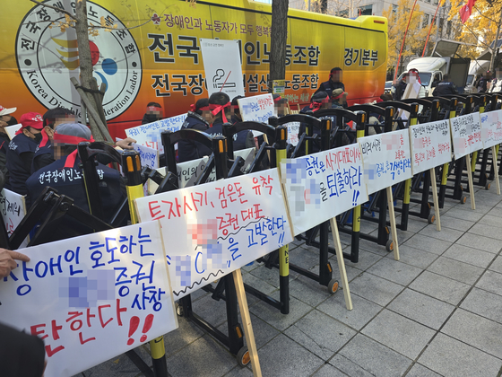 한 장애인 단체가 지난 20일 오전 서울 여의도의 한 증권사 앞에서 약정 기부금을 내놓으라며 해당 증권사 임원을 규탄하는 집회를 열고 피켓 시위를 하고 있다. 손성배 기자