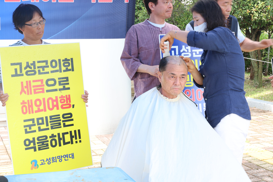 경남 고성군의회 앞에서 시민단체 고성희망연대가 군의회의 외유성 국외연수 취소를 촉구하며 삭발식을 진행하고 있다. [연합뉴스]