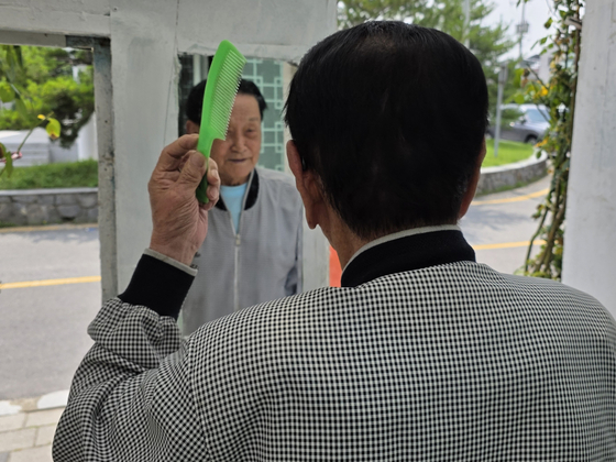 대문에 걸린 거울을 보는 한종상. 김서원 기자