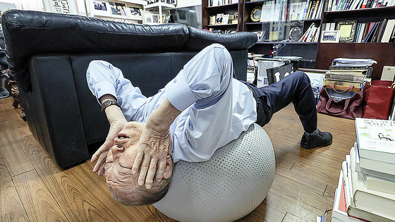 이용만 전 재무부 장관이 볼 위에 누워 맨손 체조를 하고 있다. 김성룡 기자