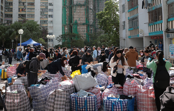 28일(현지시간) 홍콩 신계(New Territory) 타이포구의 공공 아파트단지 웡 푹 코트(宏福苑) 화재 현장 인근에서 자원봉사자들이 화재 피해 주민들에게 기부받은 물품을 나눠주고 있다. 뉴스1