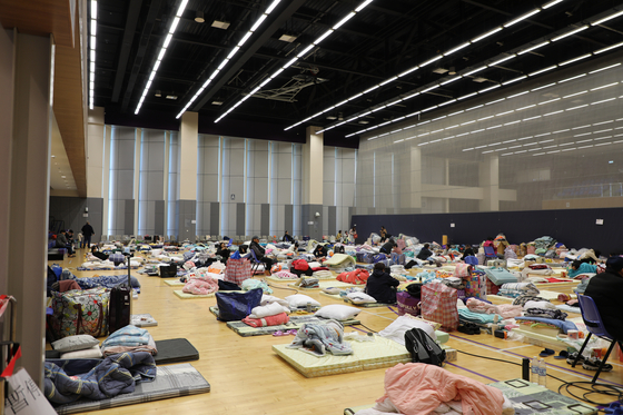 28일 오전 10시 44분(현지시간)께 임시 대피소로 쓰이는 홍콩 북부 타이포 퉁 청 시민회관 3층 강당에 화재 피해자들이 매트리스를 깐 잠자리 옆으로 구호물자를 놓아두고 휴식을 취하고 있다. 연합뉴스