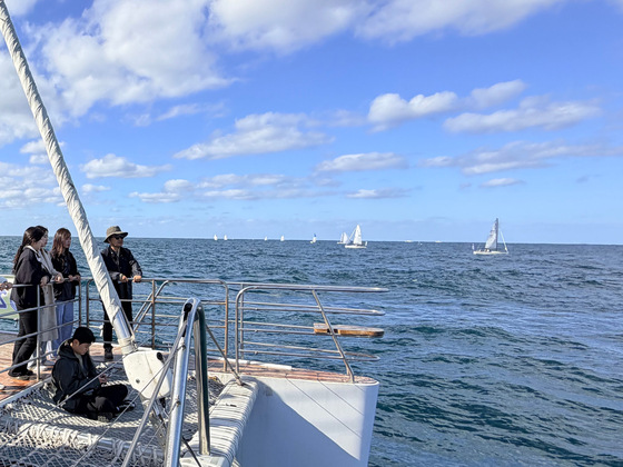 지난 28일 오후 제주시 도두항 요트부두 인근 해역에서 제1회 제주컵 국제요트대회에 참가한 7개국 선수들이 기량을 겨루는 모습을 지켜보는 대회 관람객들. 최충일 기자