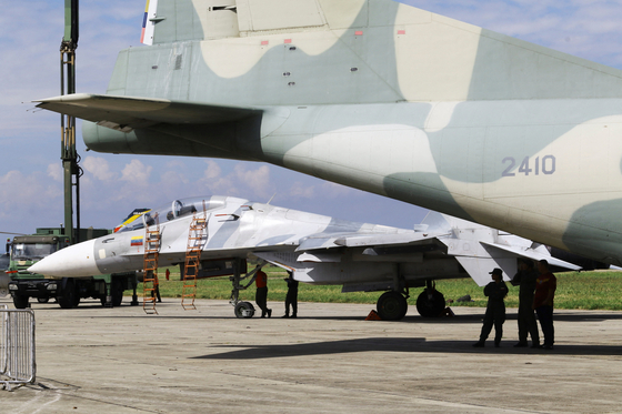 도널드 트럼프 미국 대통령이 29일(현지시간) 베네수엘라 상공과 주변 영공을 “전면 폐쇄”해야 한다고 말한 후, 베네수엘라 마라카이에서 열린 2025년 베네수엘라 항공 박람회에서 군인들이 군용기 아래에 서 있다. 로이터=연합뉴스