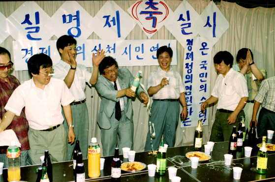 경제정의실천시민연합 관계자들이 실명제 소식에 축배를 들고 있다. [중앙포토]