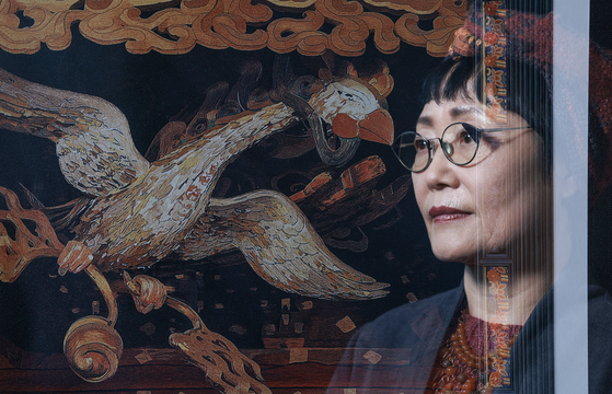 자신의 자수공예를 '실그림'이라고 칭하는 손인숙 작가. 경기도 용인시 기흥구의 실그림갤러리에는 전통과 현대를 잇는 정교한 자수작품들이 빈틈없이 전시돼 있다. 손 작가 얼굴과 합성한 작품은 강화도 전등사 대웅전의 봉황 닫집을 실그림으로 옮긴 것이다. 권혁재 사진전문기자