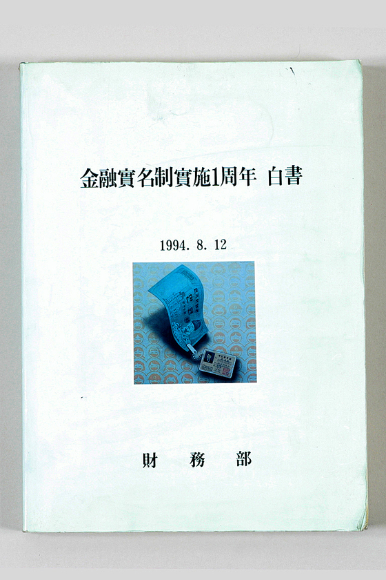 실명제 1주년 백서. 1만원권에 주민등록증을 붙여 금융실명제를 표현했다. [사진 신한은행 한국금융사박물관]