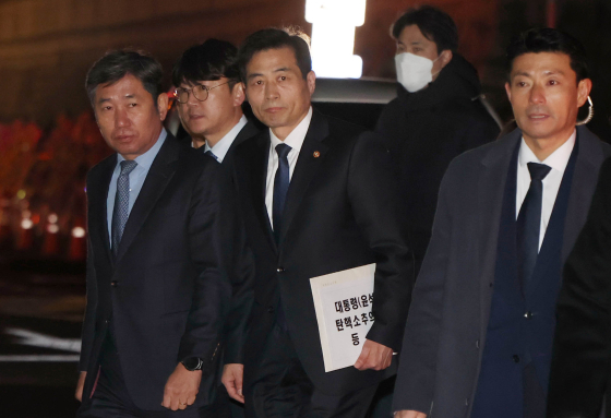 윤석열 대통령의 ‘국회 탄핵소추의결서’를 전달하기 위해 김민기 국회 사무총장(왼쪽에서 두 번째)이 지난해 12월14일 서울 용산 대통령실 청사로 향하는 모습. 대통령실사진기자단