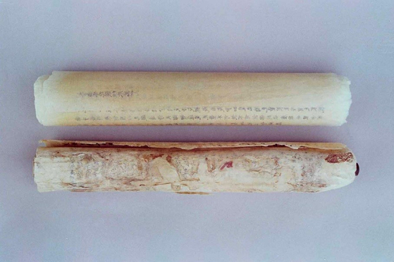 발견 당시의 신라 백지묵서(신라 사경) 두 축, 아래 축1은 말려 있는 것을 펼쳐 내용을 확인하기 어려울 만큼 손상이 심했다. 사진 리움미술관