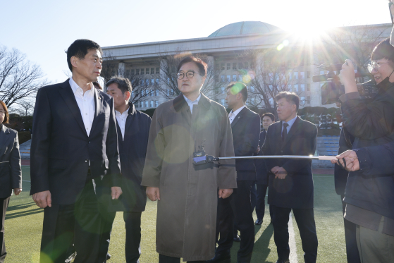 우원식 국회의장이 지난해 12월 4일 오전 서울 여의도 국회에서 간밤에 윤석열 대통령의 비상계엄 선포로 국회로 진입했던 계엄군 헬기가 착육했던 운동장을 살피며 김민기 사무총장과 대화하는 모습. 뉴스1