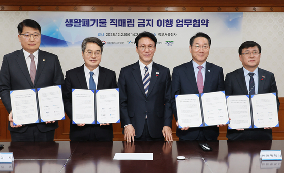 김민석 국무총리가 2일 서울 종로구 정부서울청사에서 열린 생활폐기물 직매립 금지 관련 업무협약 체결식에서 3개 지자체장과 기념 촬영을 하고 있다.    연합뉴스