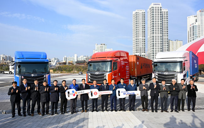 울산 태화강 국가정원 남구둔치에서 진행된 ‘수소전기 트랙터 실증 사업 차량 인도식’ 행사에서 참석자들이 기념사진을 촬영하고 있다.왼쪽 9번째부터김두겸 울산광역시장, 롯데글로벌로지스 권순근 TLS사업본부장, 안효대 울산광역시 경제부시장, 현대자동차 전략기획실장 김동욱 부사장, 현대글로비스 조삼현 SCM사업부장.