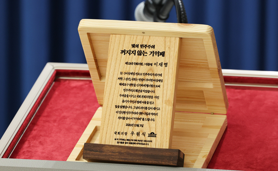 (서울=뉴스1) 허경 기자 = 3일 서울 용산 대통령실 청사에서 열린 5부 요인 초청 오찬 관련 브리핑에서 '빛의 민주주의 꺼지지 않는 기억패'가 공개되고 있다. 이재명 대통령은 이날 오찬에서 우원식 국회의장으로부터 지난해 12월 3일 계엄군에 의해 부서졌던 국회 집기들을 재활용해 만든 '기억패'를 전달 받았다. 2025.12.3/뉴스1