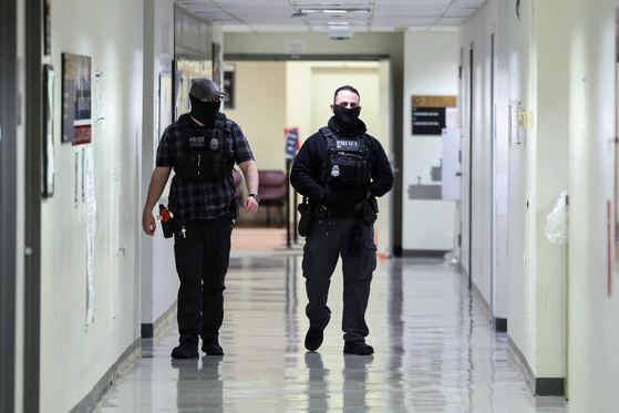 지난달 13일(현지시간) 미국 뉴욕시 페더럴 플라자 이민법원의 모습. 마스크를 쓴 연방요원들이 복도를 걷고 있다. AFP=연합뉴스